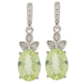 Oval green peridot earrings set in 14K white gold with diamond accents, showcasing elegant design and sparkle.